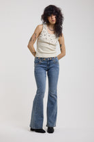 Blue flare bootcut jeans with eyelet cut out detail, worn by model
