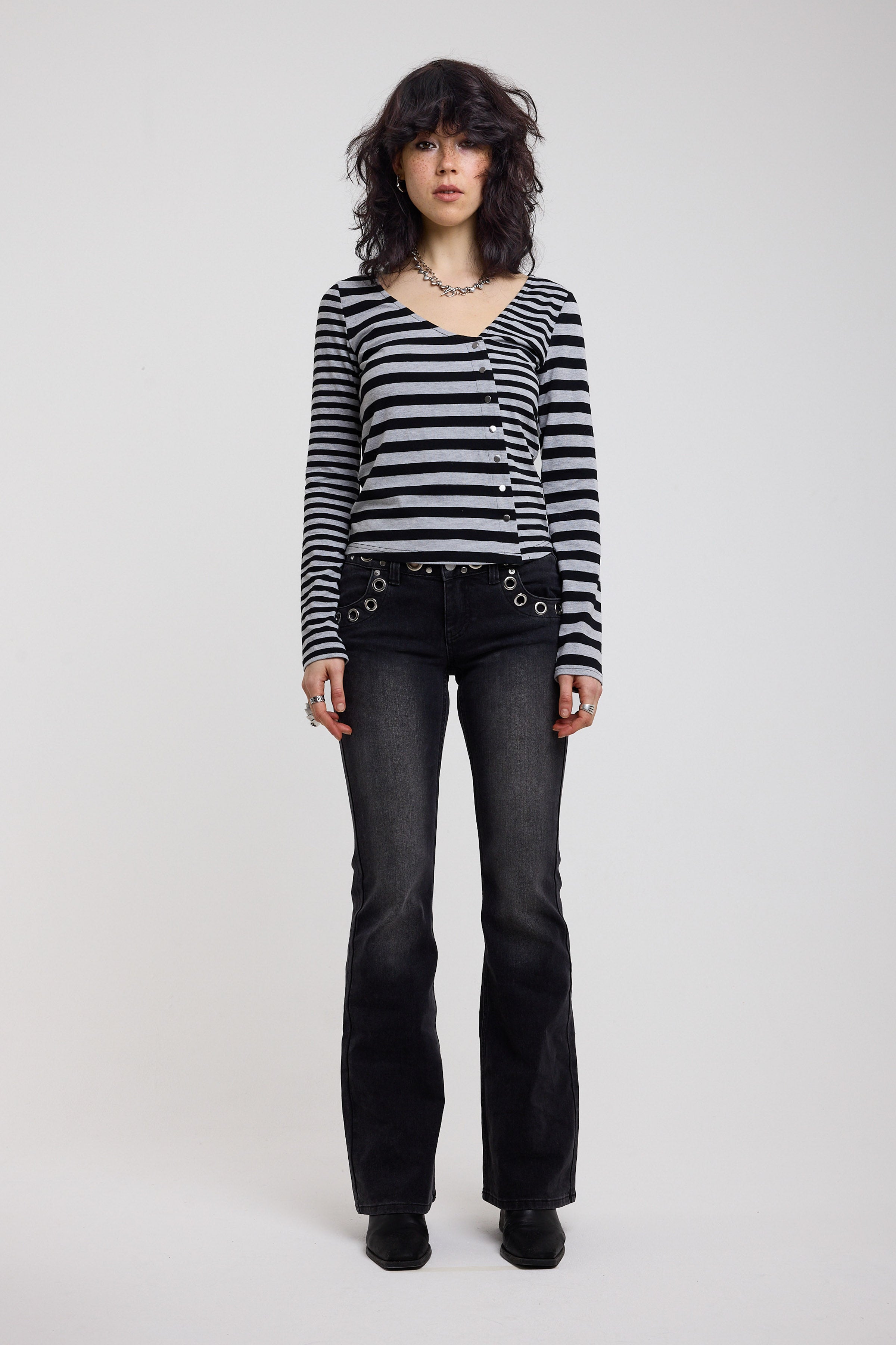 Washed black flare bootcut jeans with eyelet cut out detail, worn by model