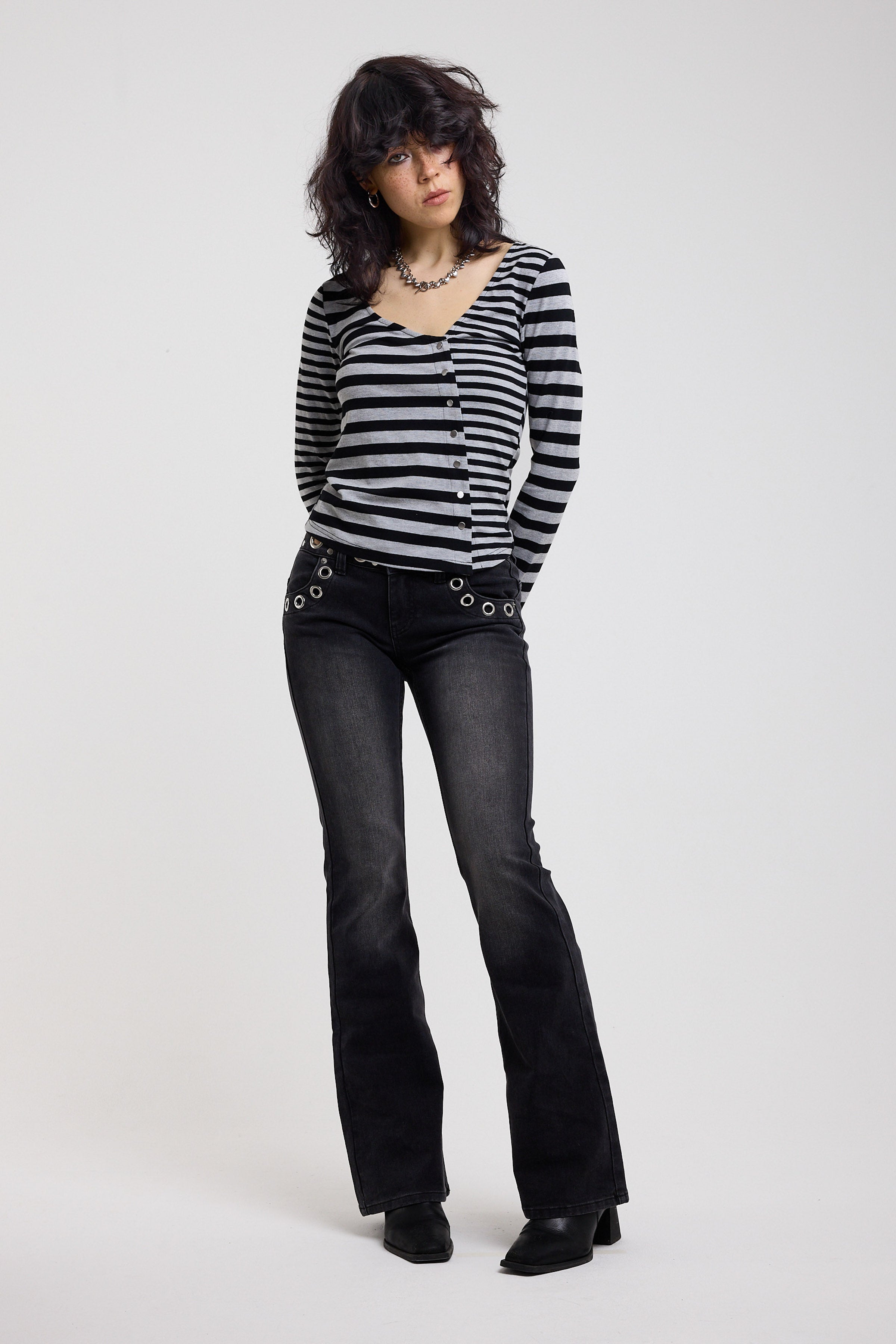 Washed black flare bootcut jeans with eyelet cut out detail, worn by model