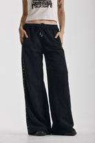 Washed black wide leg sweatpants with mixed metal studs, worn by model