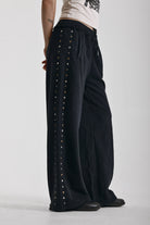 Washed black wide leg sweatpants with mixed metal studs, worn by model
