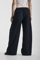 Washed black wide leg sweatpants with mixed metal studs, worn by model