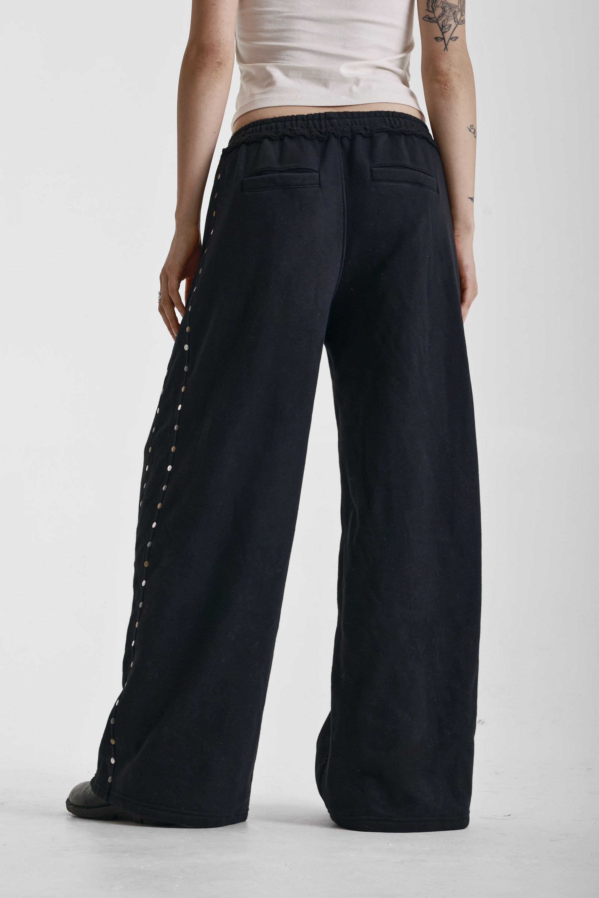 Washed black wide leg sweatpants with mixed metal studs, worn by model