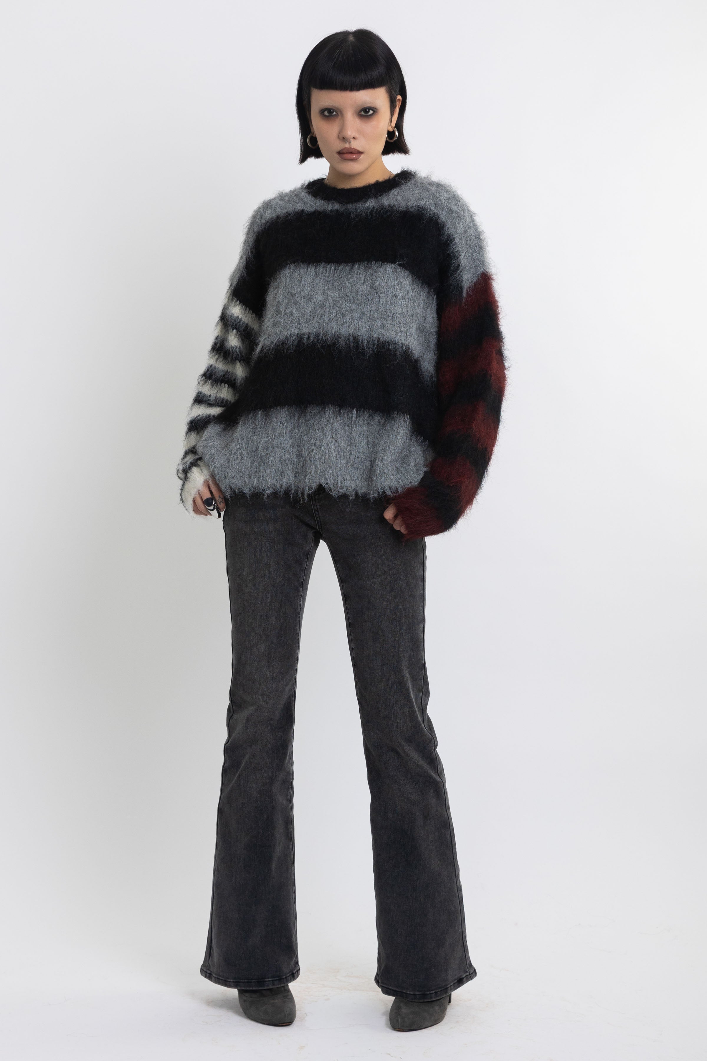 Black and grey colourblock stripe fuzzy knit jumper with contrasting stripe sleeves, worn by model