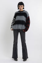 Black and grey colourblock stripe fuzzy knit jumper with contrasting stripe sleeves, worn by model