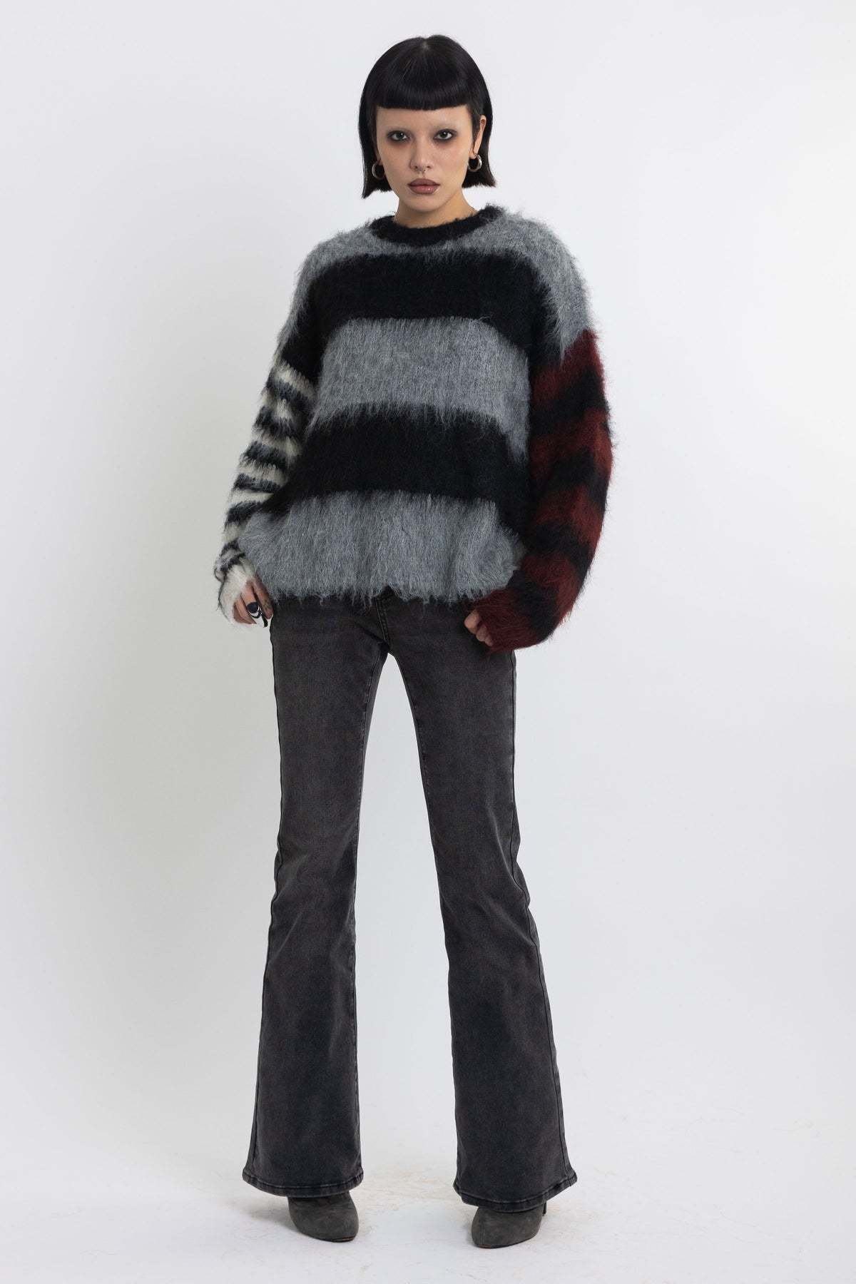 Black and grey colourblock stripe fuzzy knit jumper with contrasting stripe sleeves, worn by model