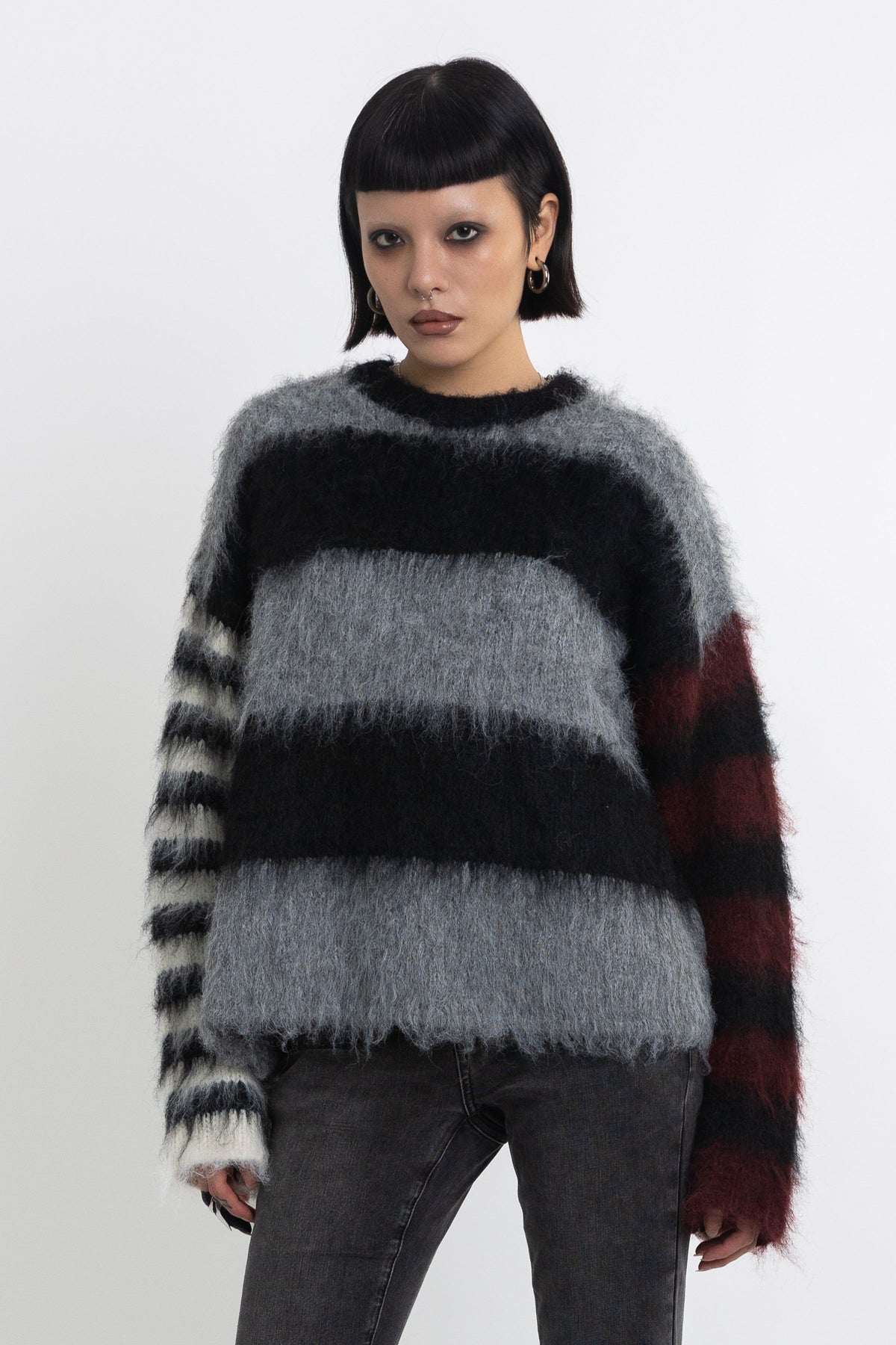 Black and grey colourblock stripe fuzzy knit jumper with contrasting stripe sleeves, worn by model