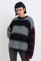 Black and grey colourblock stripe fuzzy knit jumper with contrasting stripe sleeves, worn by model