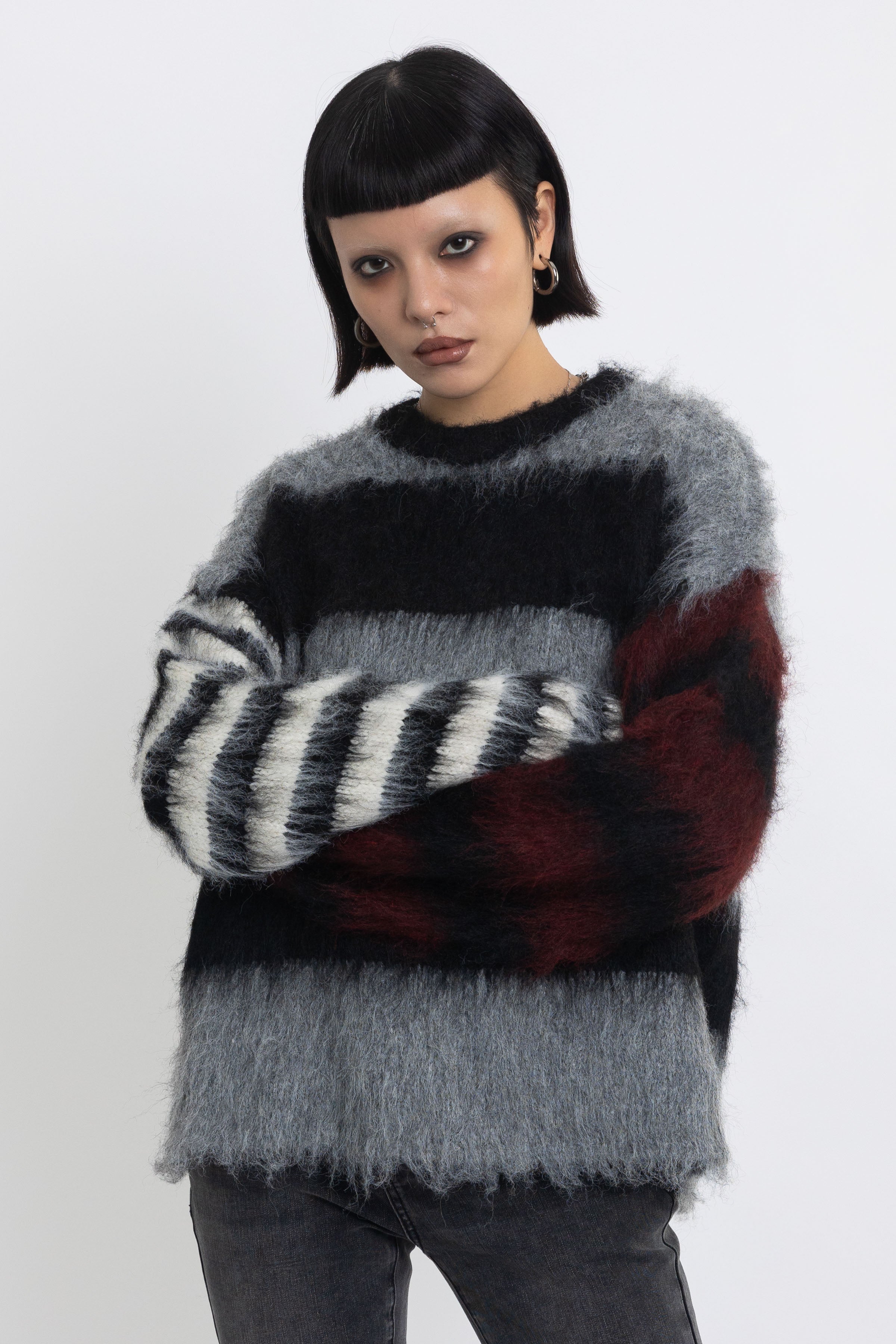 Black and grey colourblock stripe fuzzy knit jumper with contrasting stripe sleeves, worn by model