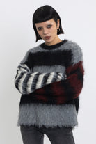 Black and grey colourblock stripe fuzzy knit jumper with contrasting stripe sleeves, worn by model