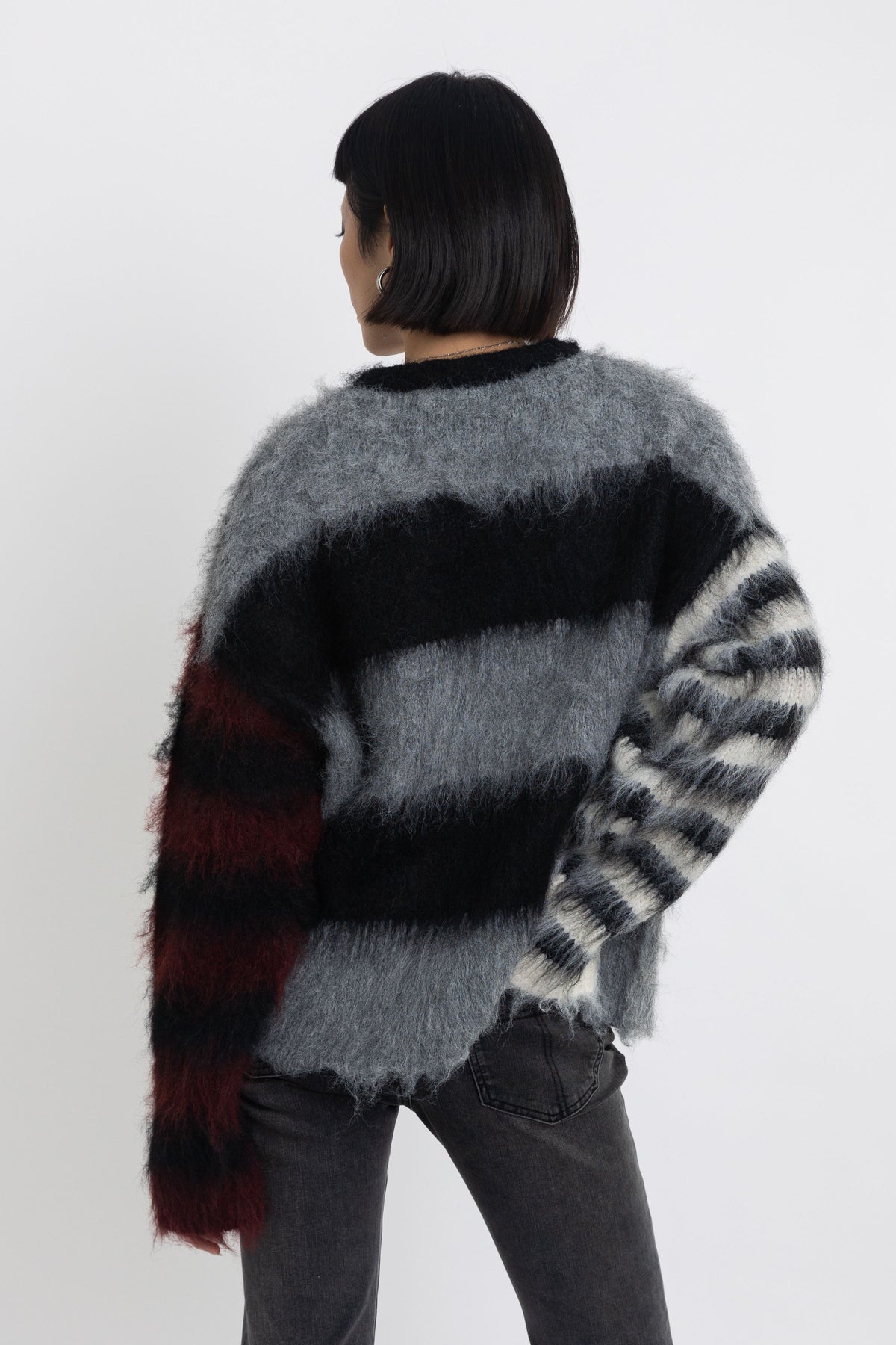 Black and grey colourblock stripe fuzzy knit jumper with contrasting stripe sleeves, worn by model