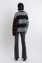 Black and grey colourblock stripe fuzzy knit jumper with contrasting stripe sleeves, worn by model