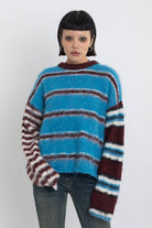 Blue and burgundy stripe fuzzy knit jumper, worn by model