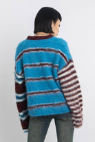 Blue and burgundy stripe fuzzy knit jumper, worn by model