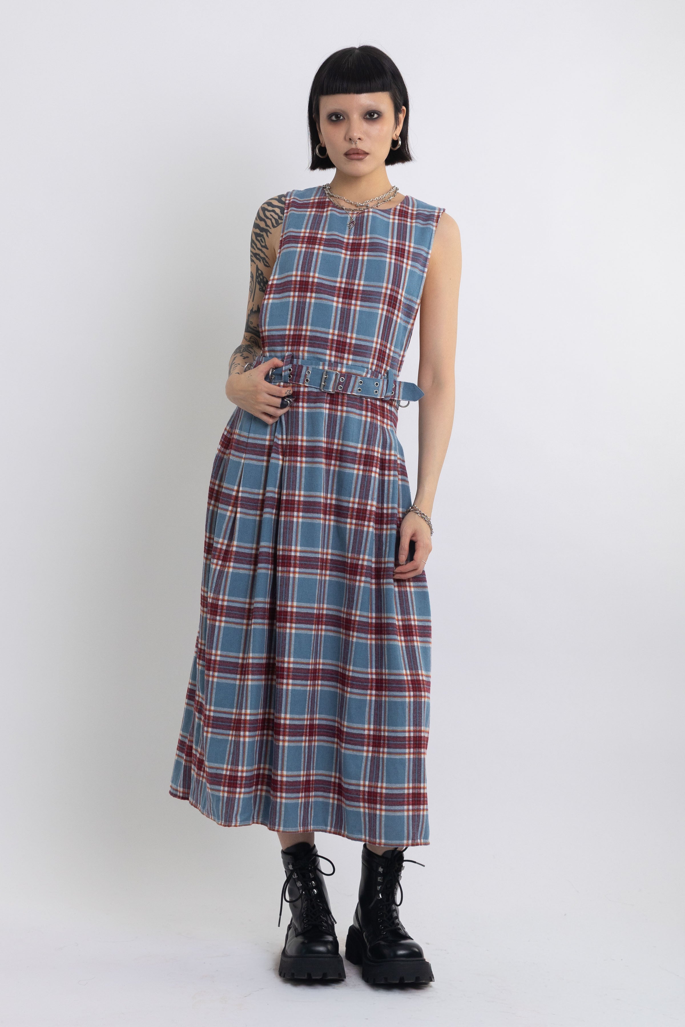 Sleeveless blue plaid check pinafore midi dress with eyelet hardware belt, worn by model
