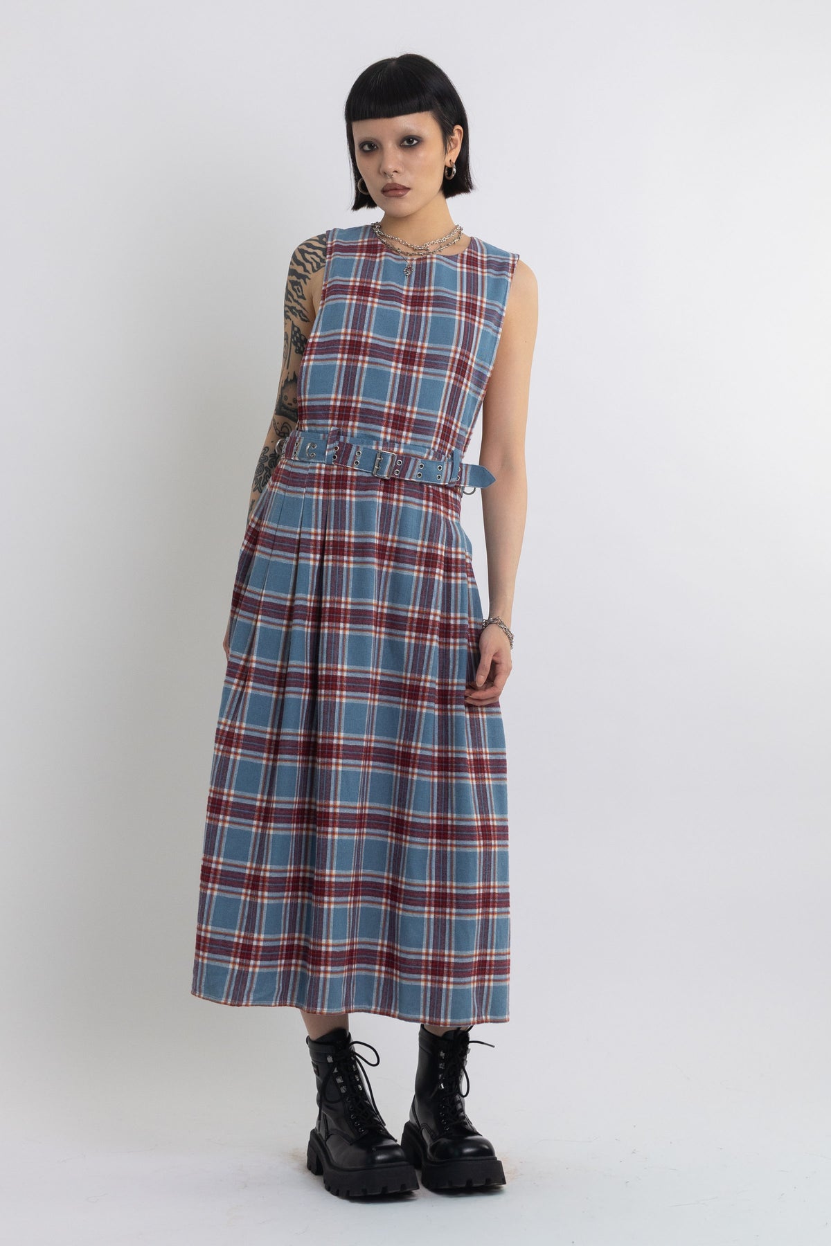 Sleeveless blue plaid check pinafore midi dress with eyelet hardware belt, worn by model