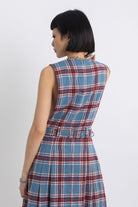 Sleeveless blue plaid check pinafore midi dress with eyelet hardware belt, worn by model