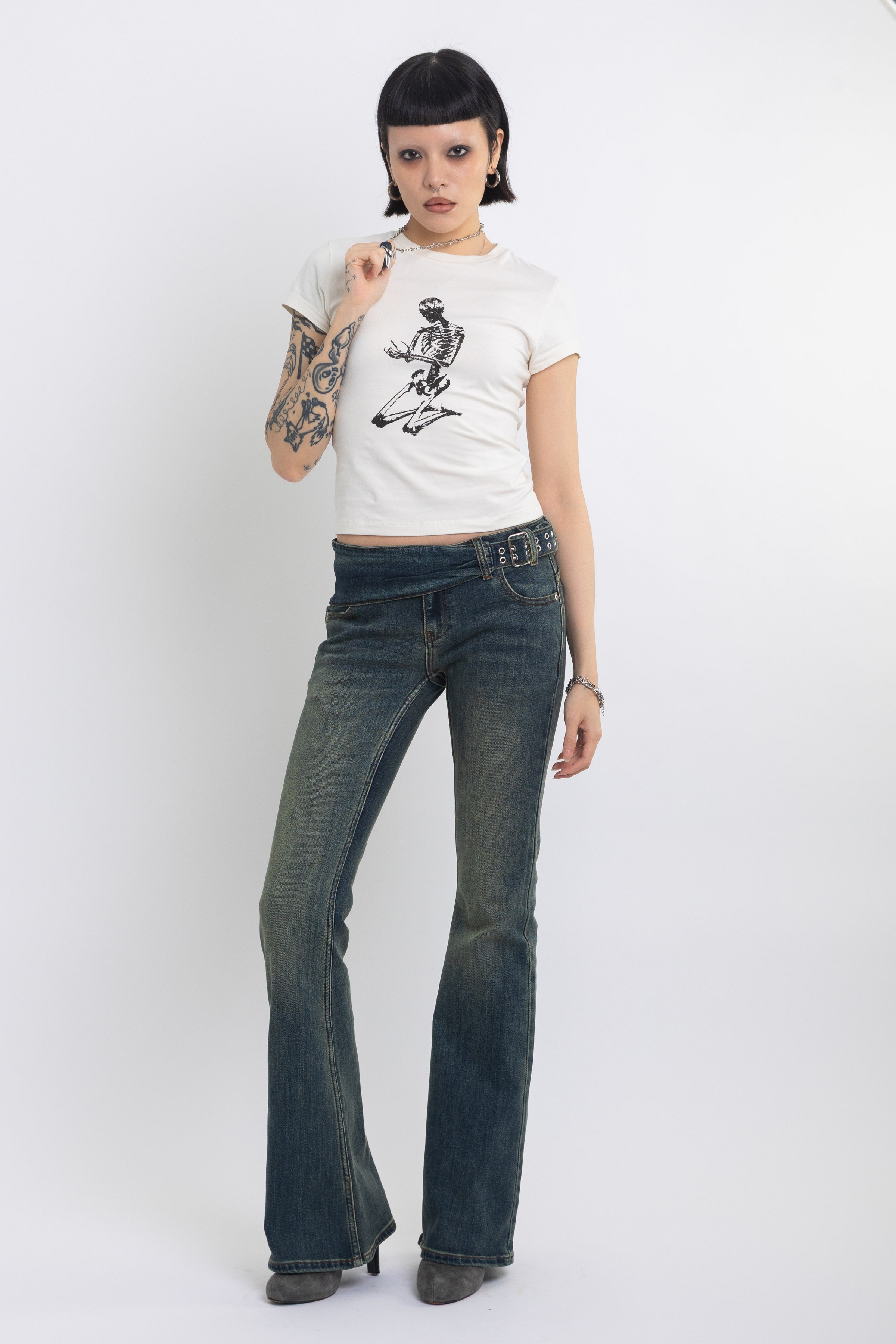Dirty blue wash belted low rise flare jeans with eyelet detail, worn by model