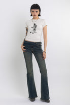 Dirty blue wash belted low rise flare jeans with eyelet detail, worn by model