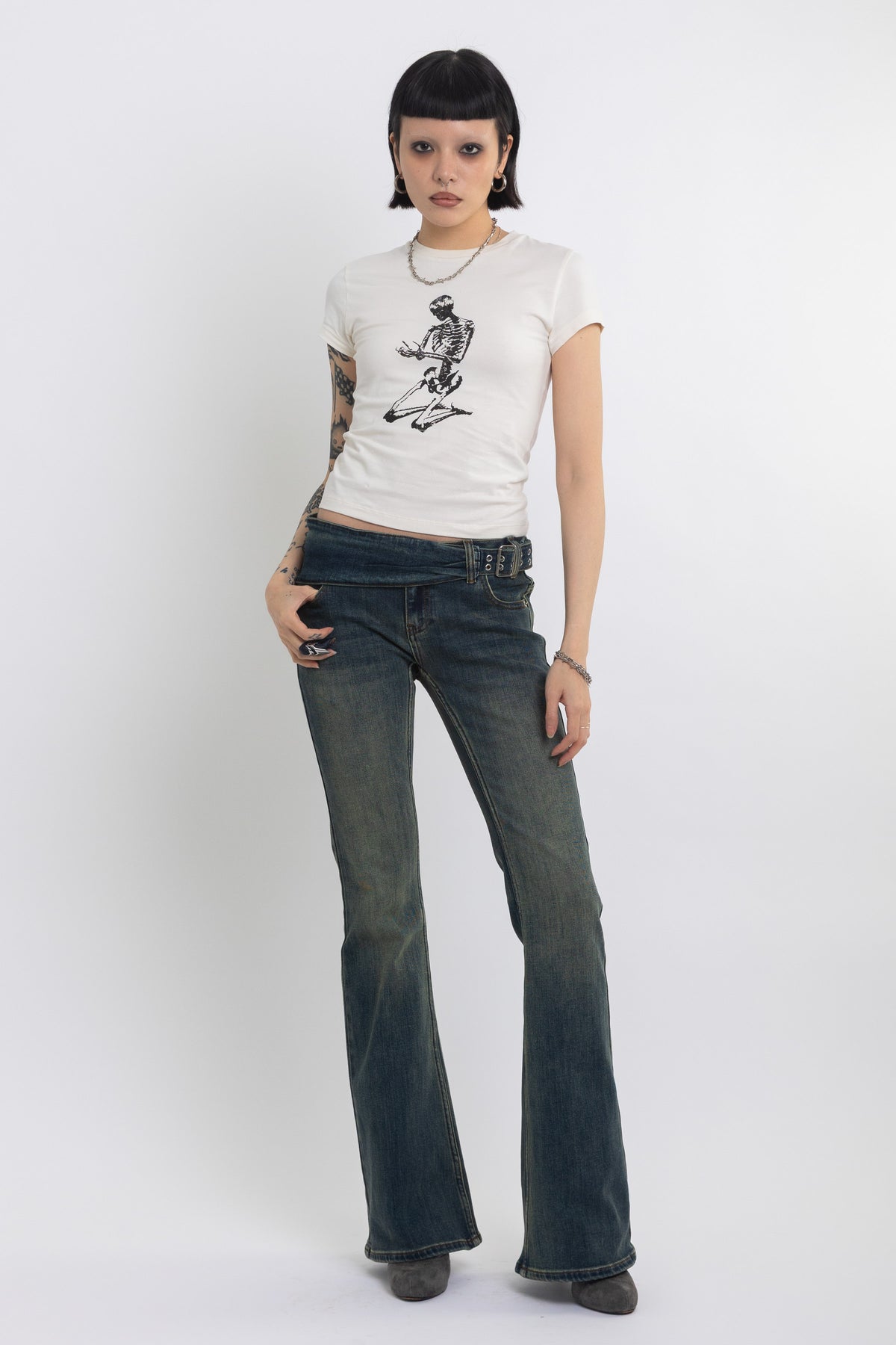 Dirty blue wash belted low rise flare jeans with eyelet detail, worn by model