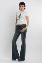 Dirty blue wash belted low rise flare jeans with eyelet detail, worn by model