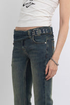 Dirty blue wash belted low rise flare jeans with eyelet detail, worn by model