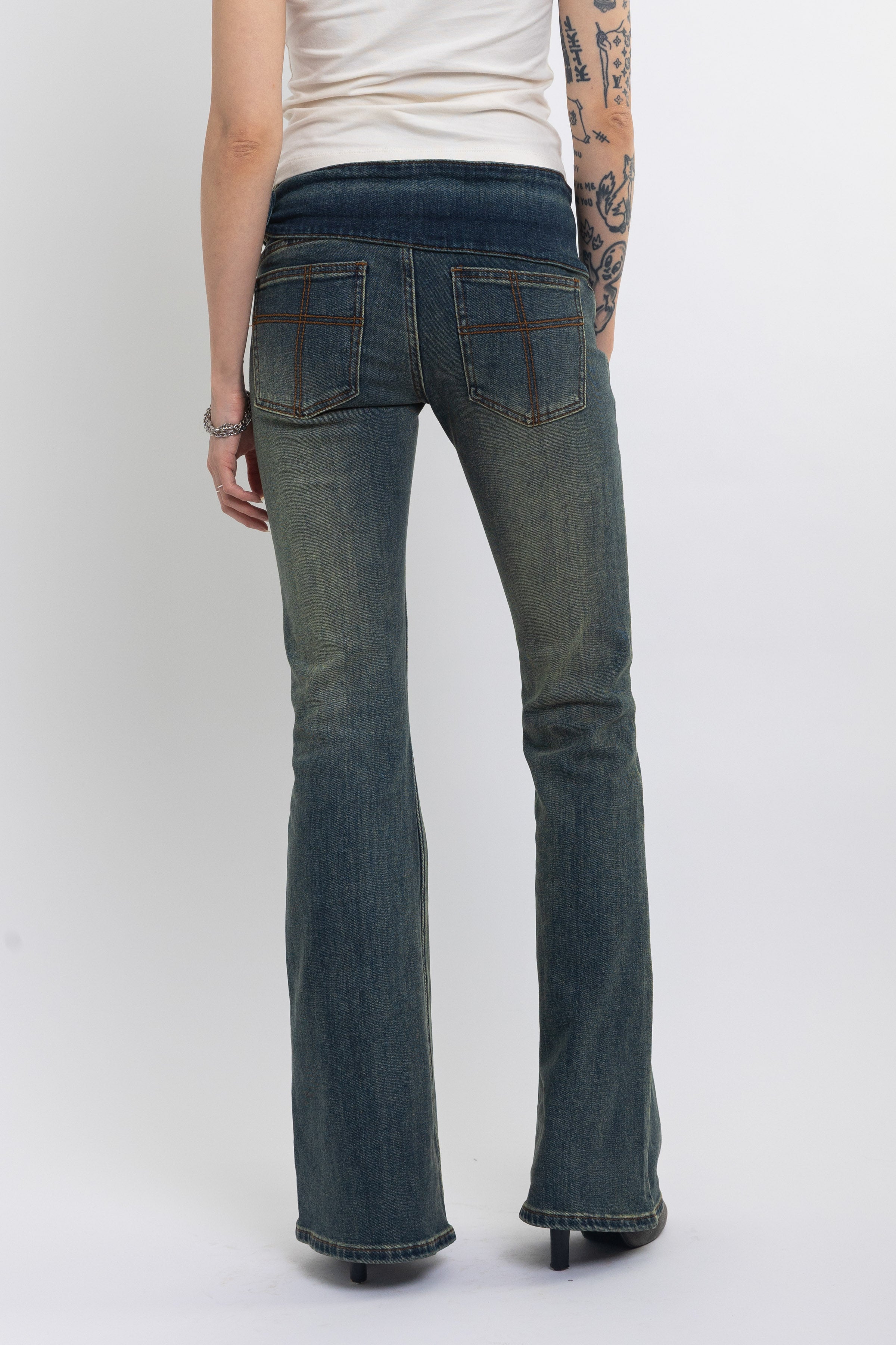 Dirty blue wash belted low rise flare jeans with eyelet detail, worn by model