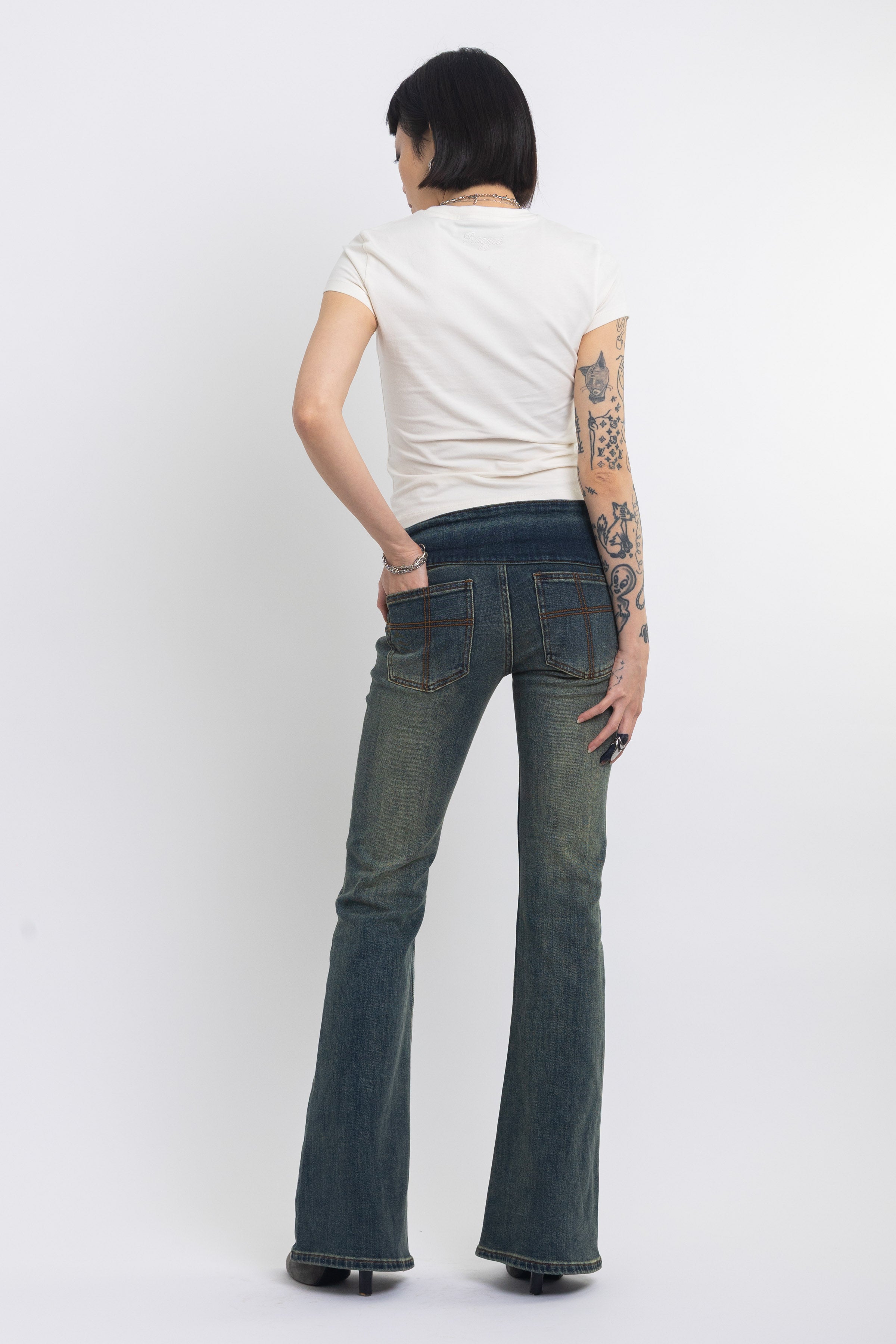 Dirty blue wash belted low rise flare jeans with eyelet detail, worn by model