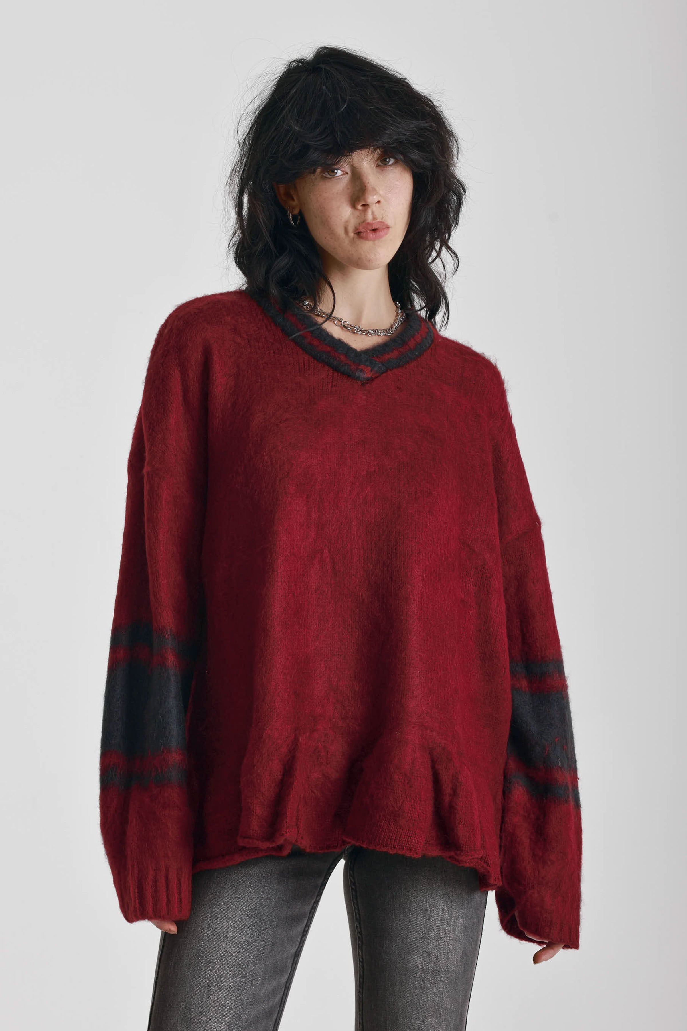 Red oversized v-neck knit jumper with varsity stripe detail and peplum hem, worn by model