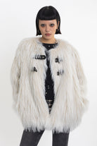 Ecru shaggy faux fur jacket with faux leather eyelet detail straps, worn by model