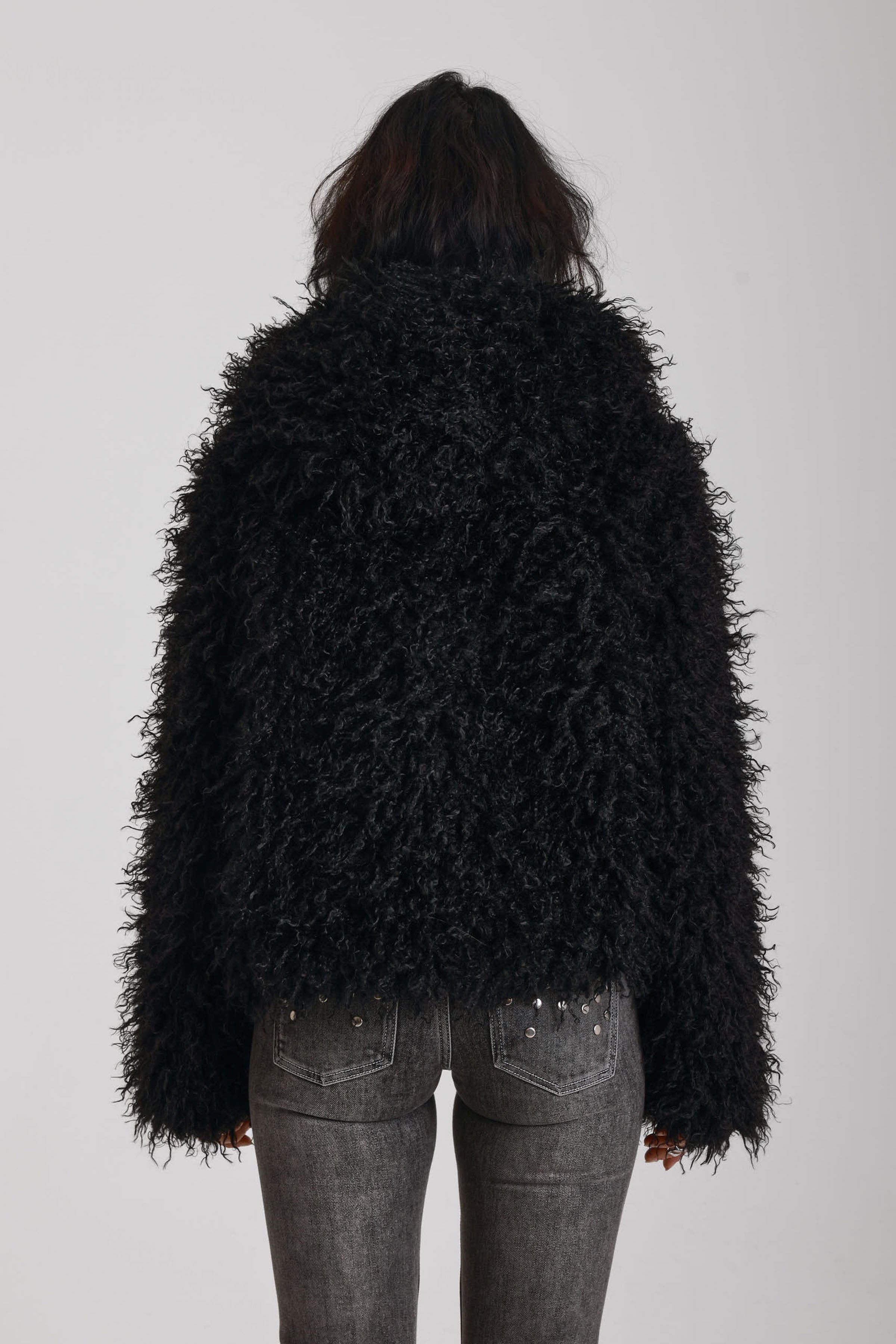 Black shaggy faux fur hooded jacket with silver clasps, worn by model