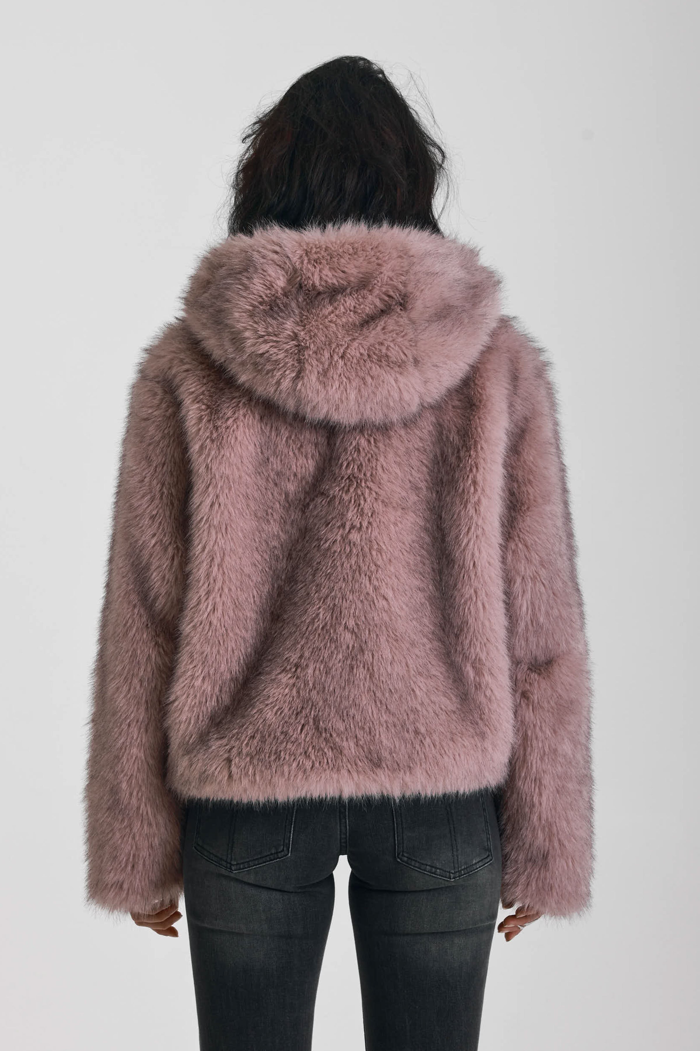 Dusty pink faux fur jacket with silver buckle clasps and a hood, worn by model