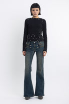 Dirty blue wash low rise flare jeans with double zip hip detail, worn by model