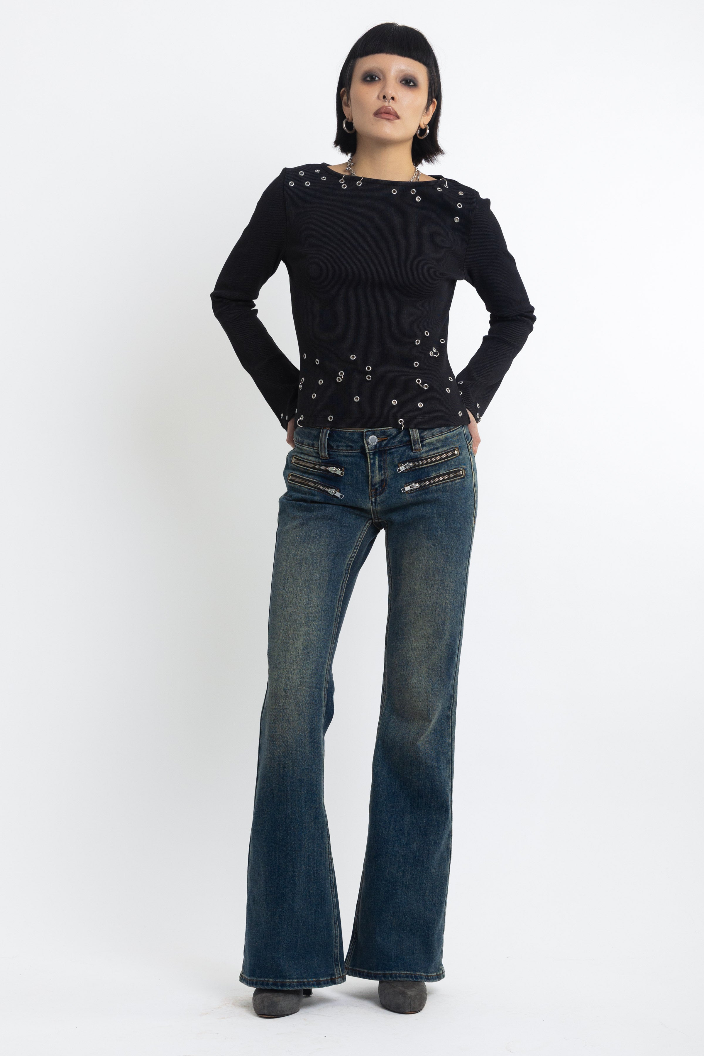 Dirty blue wash low rise flare jeans with double zip hip detail, worn by model