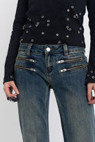 Dirty blue wash low rise flare jeans with double zip hip detail, worn by model