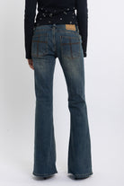 Dirty blue wash low rise flare jeans with double zip hip detail, worn by model