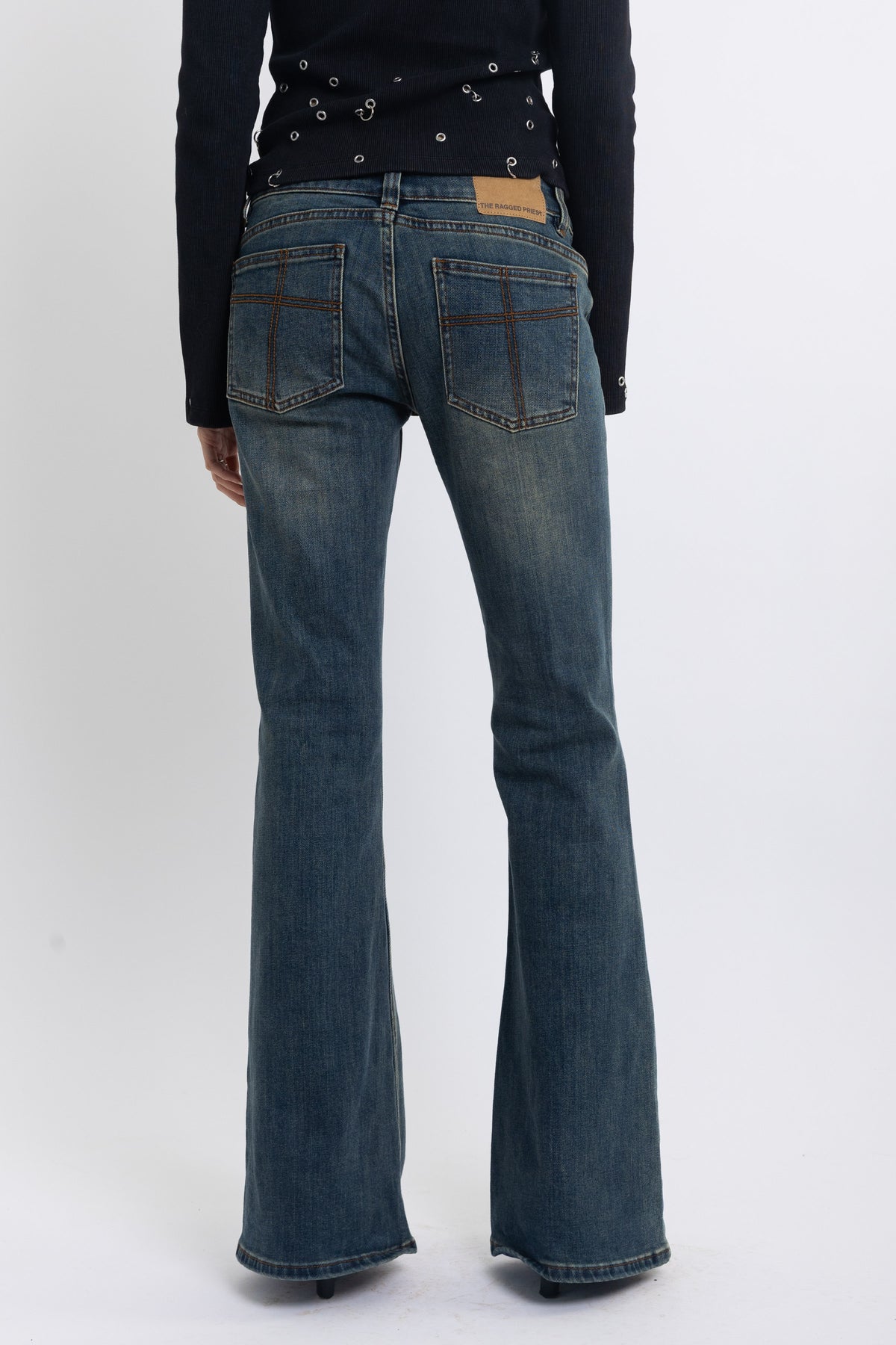 Dirty blue wash low rise flare jeans with double zip hip detail, worn by model