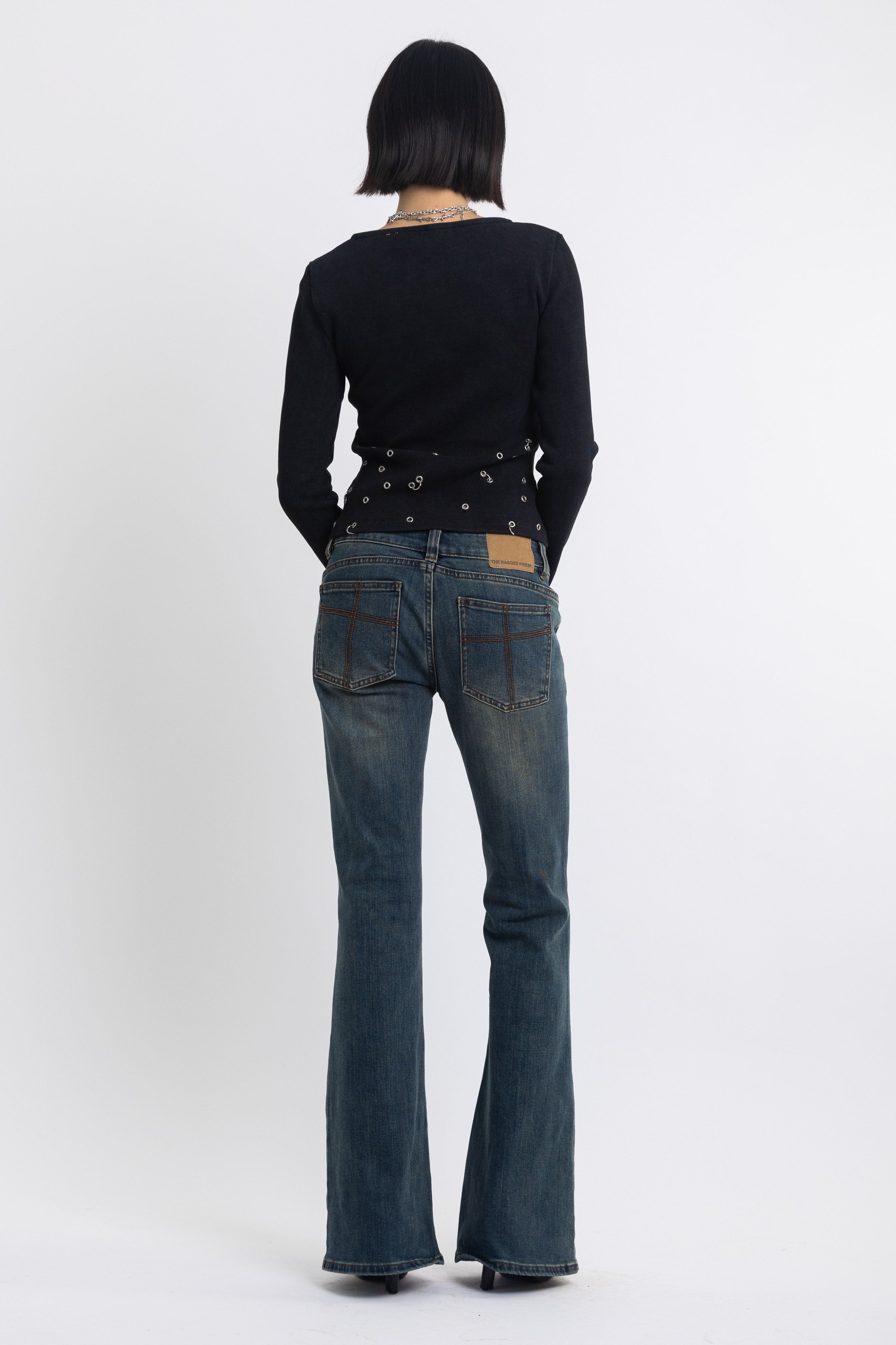 Dirty blue wash low rise flare jeans with double zip hip detail, worn by model