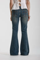 Dirty blue wash flare jeans with zip detail, worn by model
