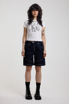 Dark rinse denim jorts with seam detail and exposed zip, worn by model