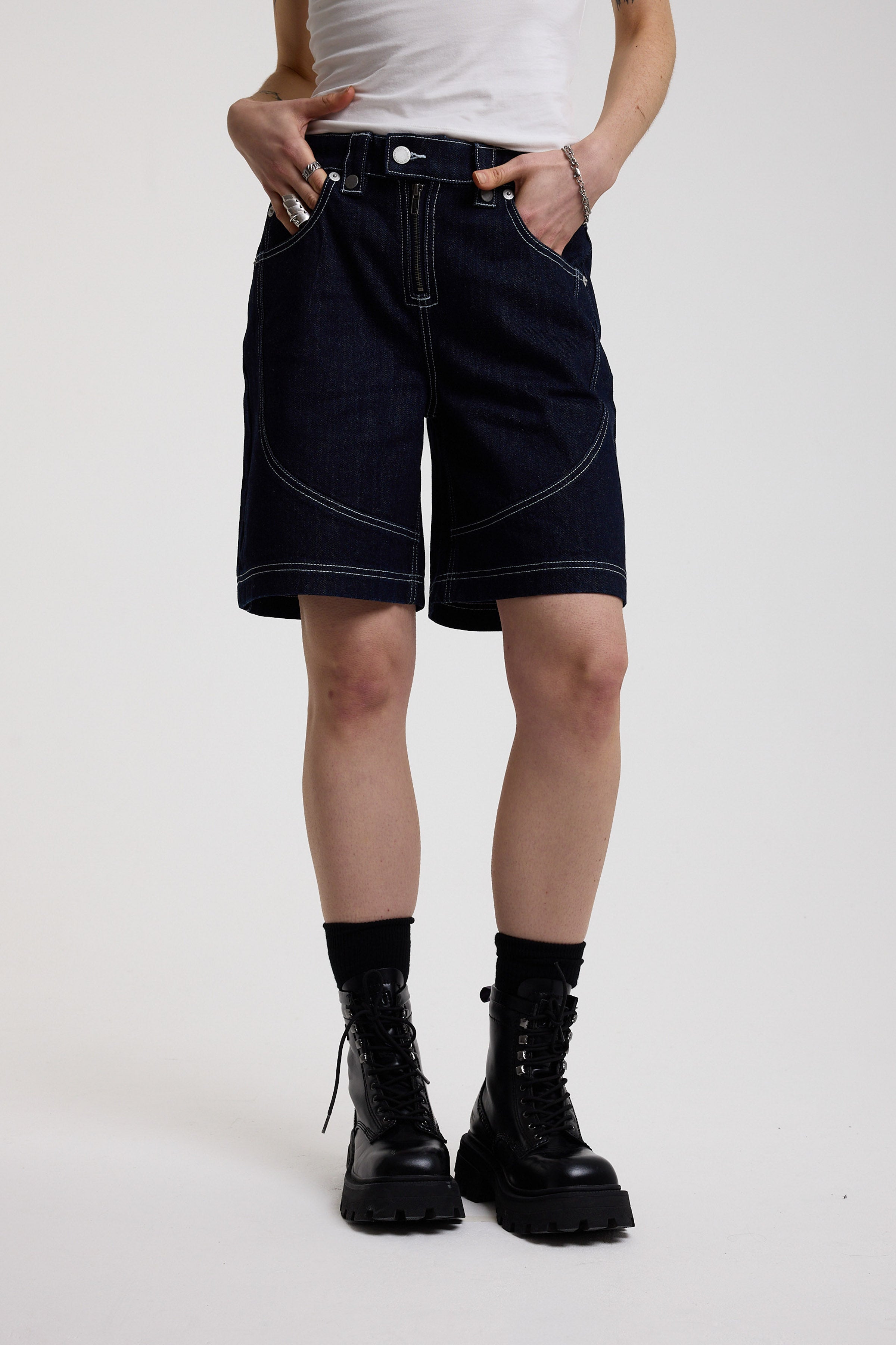 Dark rinse denim jorts with seam detail and exposed zip, worn by model