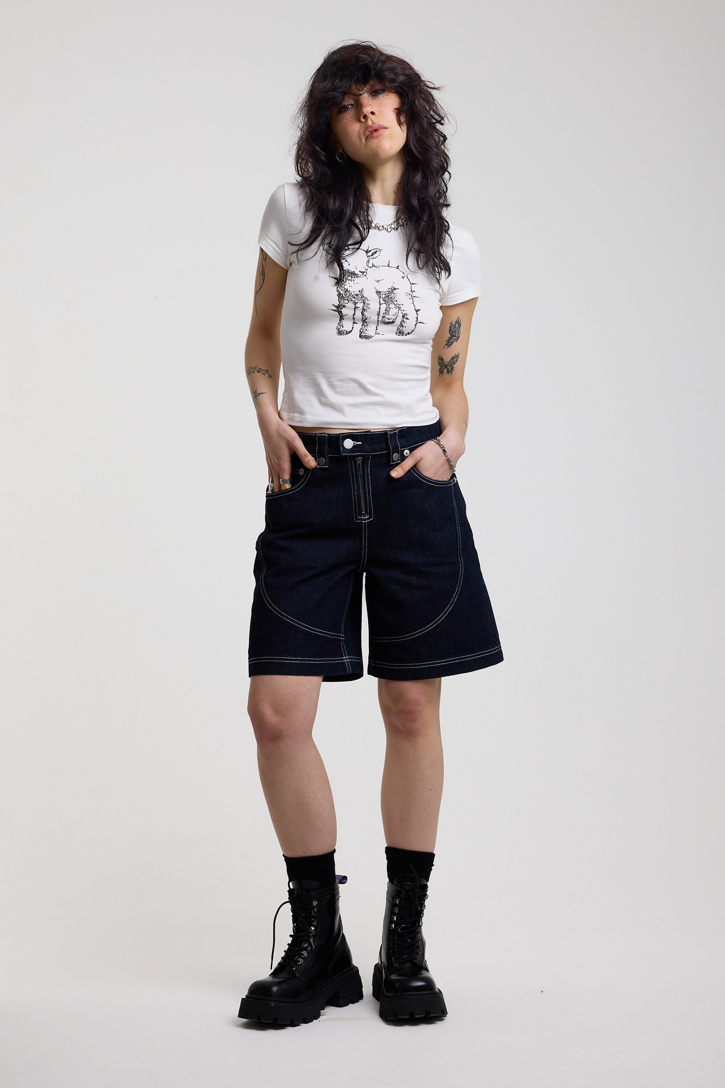 Dark rinse denim jorts with seam detail and exposed zip, worn by model