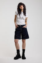Dark rinse denim jorts with seam detail and exposed zip, worn by model