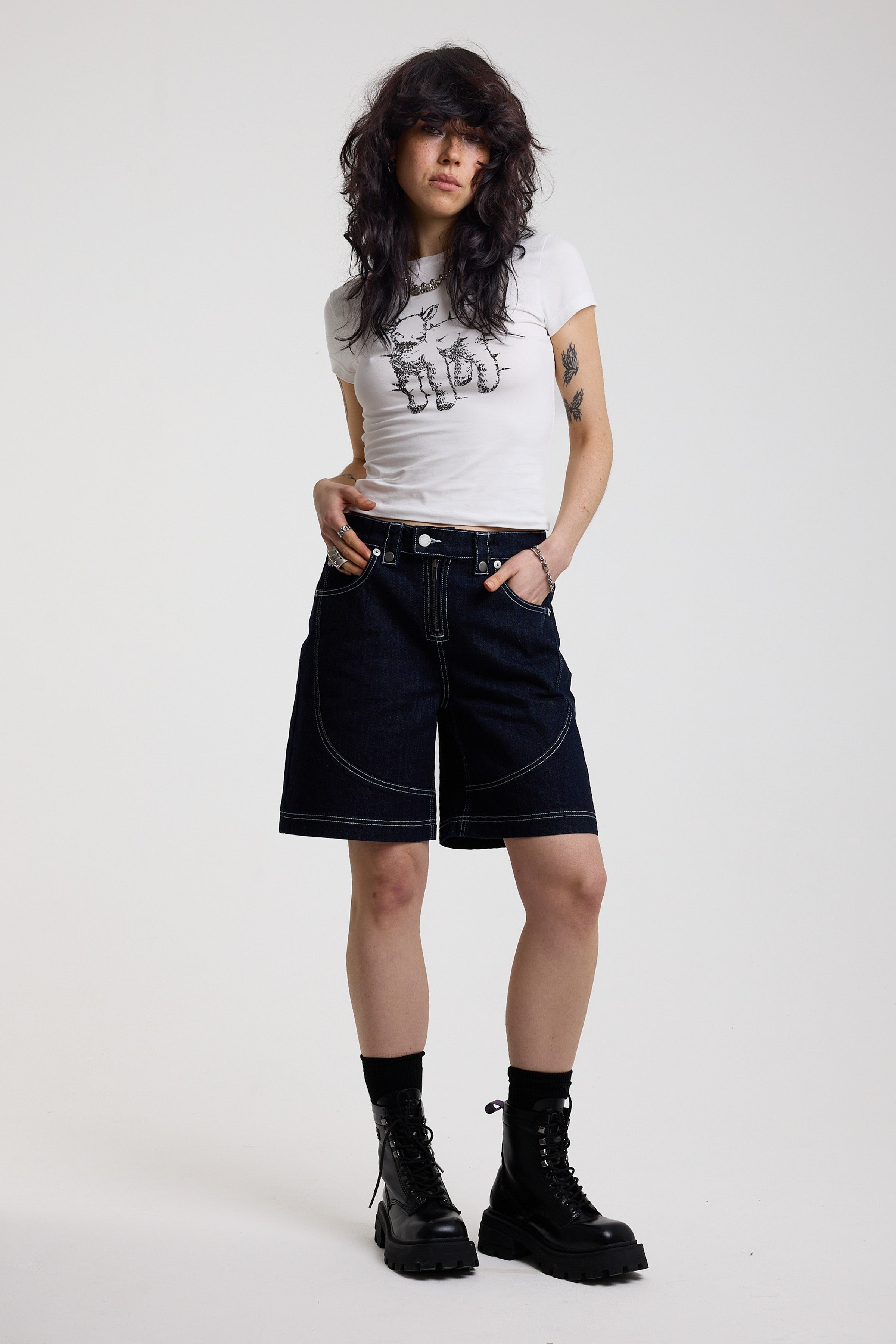 Dark rinse denim jorts with seam detail and exposed zip, worn by model