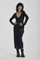 Black wrap front midi dress with silver trigger clasps and long sleeves, worn by model