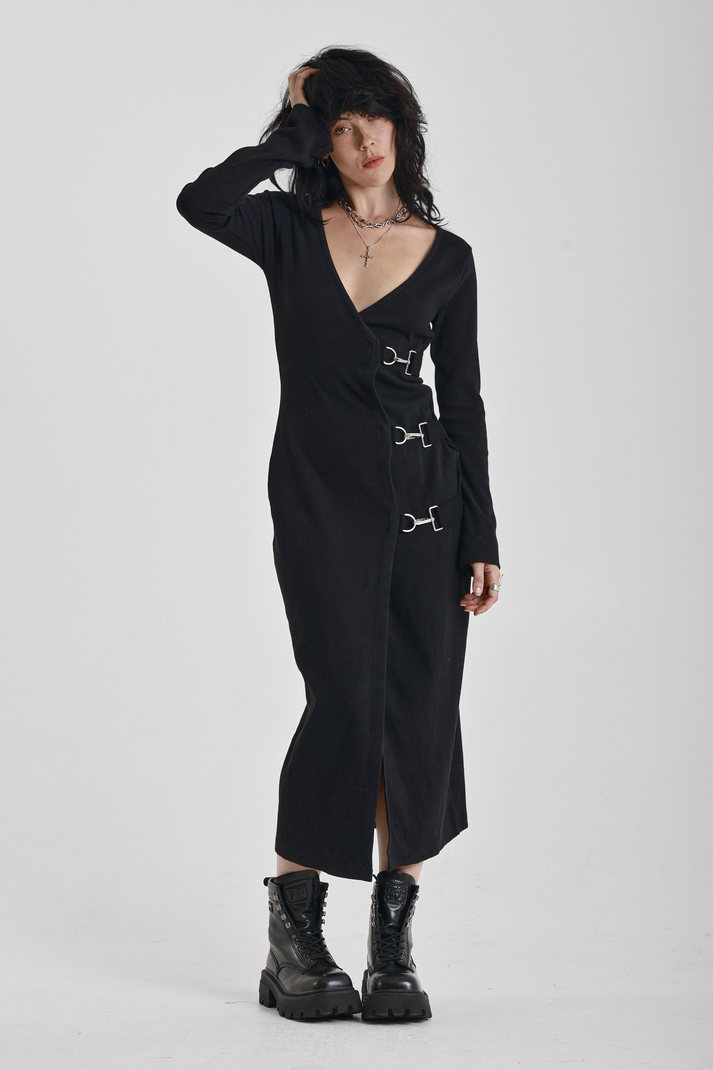 Black wrap front midi dress with silver trigger clasps and long sleeves, worn by model
