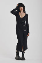 Black wrap front midi dress with silver trigger clasps and long sleeves, worn by model