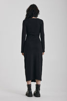 Black wrap front midi dress with silver trigger clasps and long sleeves, worn by model