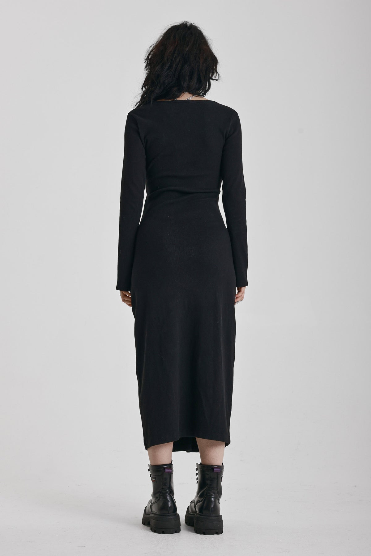 Black wrap front midi dress with silver trigger clasps and long sleeves, worn by model