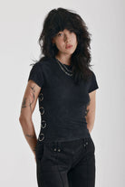 Acid wash black baby t-shirt with short sleeves and silver O-ring hardware, worn by model